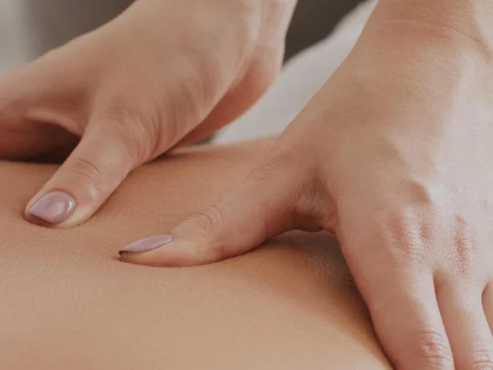 Gestes enveloppants des mains pendant un massage du dos